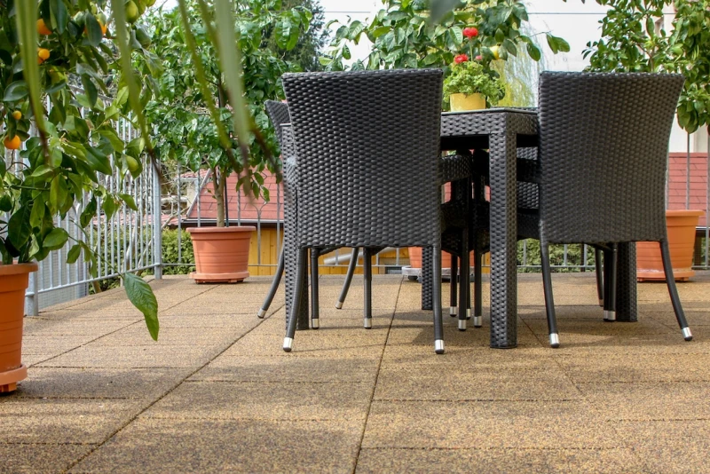 Sulla terrazza sul tetto, rivestita con le piastrelle quadrate WARCO in colore Marocco, c'è un'area salotto con gli alberi di agrumi.