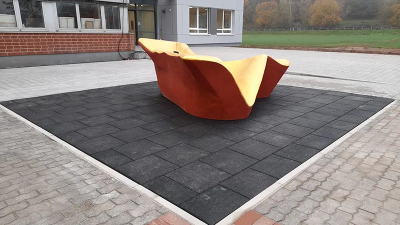 Kunstobjekt auf Fallschutzplatten im Außenbereich.