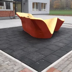 Kunstobjekt auf Fallschutzplatten im Außenbereich.