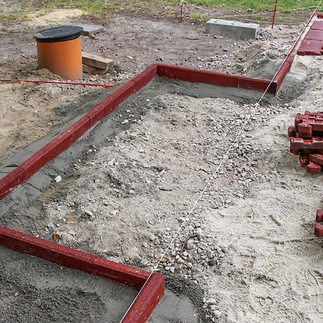 La surface du petit terrain de jeu est délimitée par des bordures WARCO qui sont encastrées dans la fondation en béton