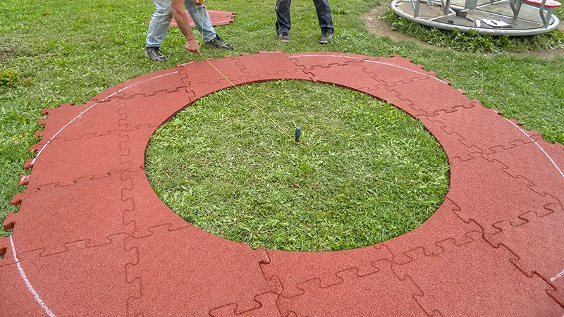 Kreisförmige Verlegung von Fallschutzplatten mit Reißverschlussverbindung.