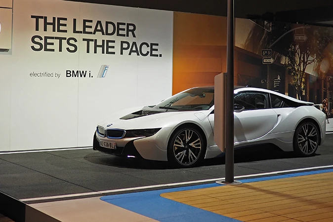 La voiture i8 de BMW est présentée lors d'un salon. La super voiture de sport est posée sur le sol noir de WARCO, qui reproduit l'asphalte d'une route.