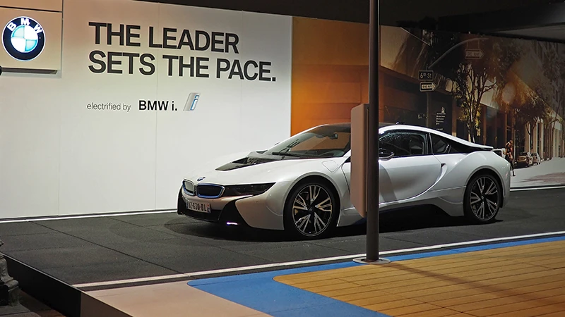 La macchina i8 di BMW viene presentata in una fiera. L'auto super sportiva si trova sul pavimento nero per eventi di WARCO, che è modellato sull'asfalto di una strada.