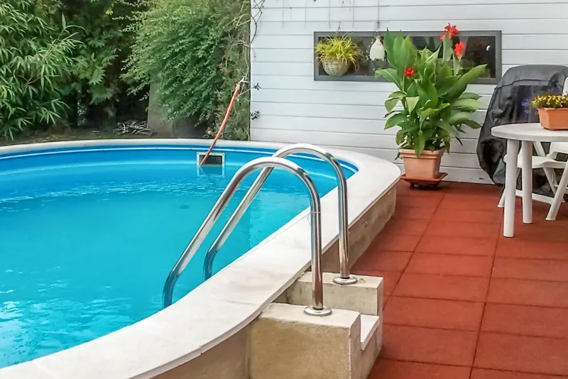 Direkt im Anschluss an die Terrasse ist ein Außenpool im Garten eingebaut. Die wasserdurchlässigen, roten WARCO-Schwimmbadfliesen sorgen für Sicherheit, trockene Füße und Komfort auf der Terrasse und am Pool.