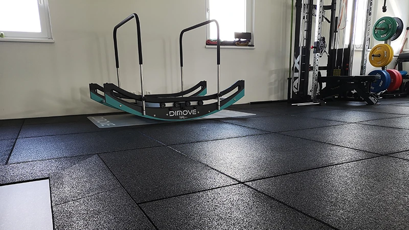 Un'area cardio con le macchine in palestra è dotata di lastre sportive nere WARCO.