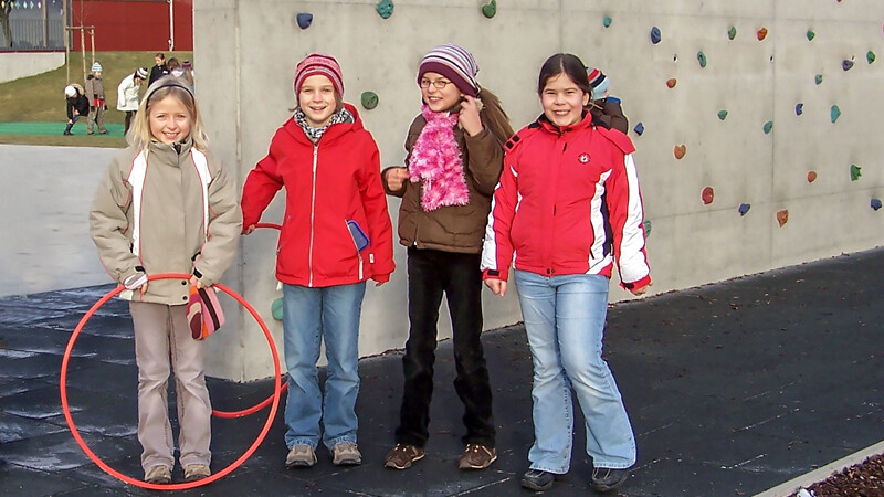 Mit Fallschutzplatten von WARCO hat man gut lachen. Diese vier fröhlichen Mädchen stehen vor einer massiv gebauten und frei stehenden Kletterwand auf dem Schulhof. Die Fallschutzplatten sorgen für den vorgeschriebenen Fallschutz auf dem Kinderspielplatz nach EN 1176.