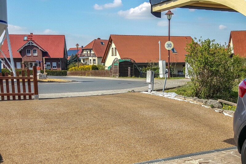 Un accès de la route publique à un garage en pente, fait de dalles en granulat de caoutchouc WARCO de couleur Café au lait.