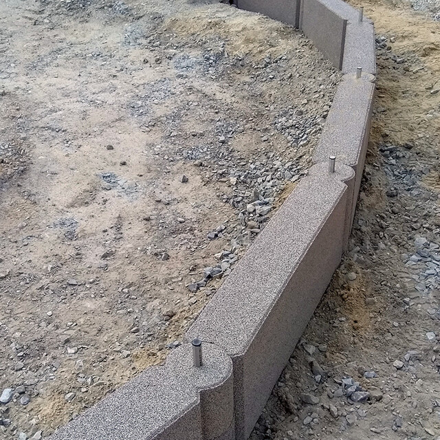 Le chantier de construction où des bordures en chaînon WARCO sont installées comme un entourage de bac à sable.