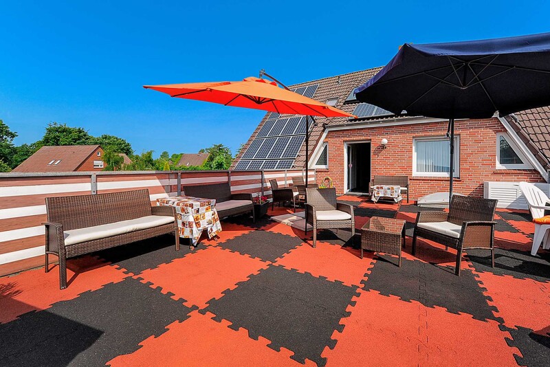 Le sol du toit-terrasse de la maison de retraites fait en carreaux de terrasse WARCO noirs et rouges type TZ, posés en damier