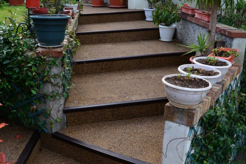Le scale esterne, realizzate con il rivestimenento antitrauma delle scale antiscivolo in colore Caffè latte di WARCO, conducono al giardino.