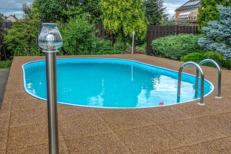 Les tons naturels de la terre du revêtement de sol WARCO perméable à l'eau, en couleur Terre cuite, s'intègrent parfaitement à la piscine enterrée dans le jardin