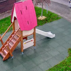 Fallschutzmatten auf einem Spielplatz mit effektiven Fallschutz unter einem Spielhaus mit geringer Fallhöhe.